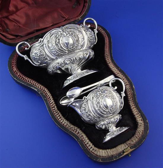 A cased late Victorian silver cream and sugar set with tongs, 7.5 oz.